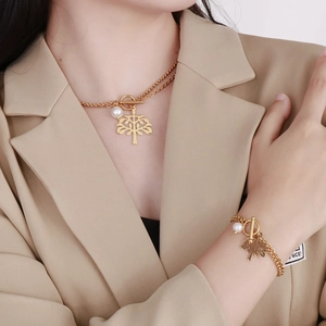 Close-up of golden tree of life necklace and bracelet set with pearl and OT buckle