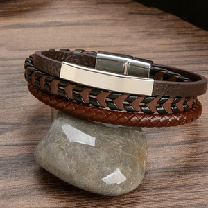 Detail of multi-layer braided leather bracelet with silver metal clasp on stone