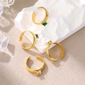 Detailed view of four gold-plated stainless steel rings with colorful square zircons
