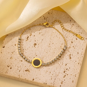Detalle de pulsera de acero dorado con disco de números romanos y sello K18