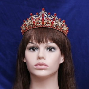 Luxury gold bridal crown with red crystals and clear rhinestones on a blue velvet base