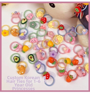 Flat lay of colorful candy-colored elastic hair ties with fruit and cartoon charms