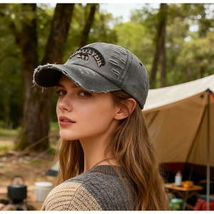 Close-up of distressed charcoal gray baseball cap with vintage embroidery and torn details