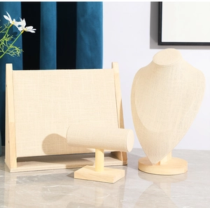 Three-piece linen and wood jewelry display set including necklace bust and bracelet stand