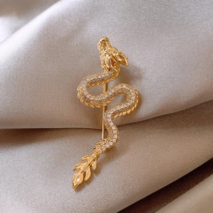 Detailed macro shot of a gold-plated dragon brooch with micro-paved sparkling cubic zirconia