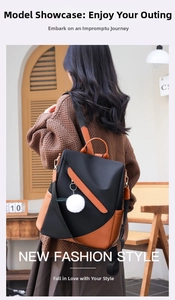 Detail of waterproof nylon backpack with caramel leather trim and white pompom charm