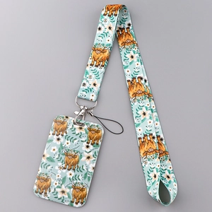 Detail van mintgroene lanyard met Highland Cow motief en bloemrijke pasjeshouder