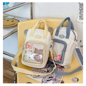 Detail of beige and blue ITA bags with clear PVC window for displaying anime pins