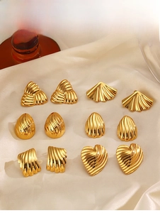 Detailed set of six pairs of vintage gold-plated earrings on beige satin fabric background