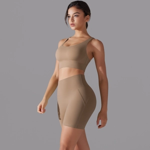 Dettaglio del set yoga con reggiseno incrociato e pantaloncini a vita alta marrone
