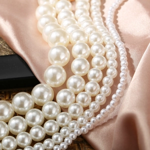 Macro shot of tiered cream-white baroque pearls with elegant luster on champagne silk