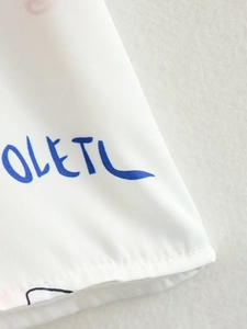 Vue détaillée du tissu blanc avec lettres OLETU bleues et texture de maille fine