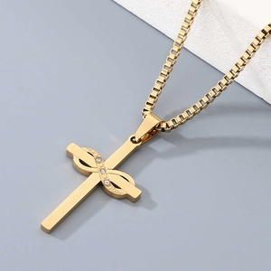 Macro shot of gold cross necklace with infinity loop and inlaid white crystals