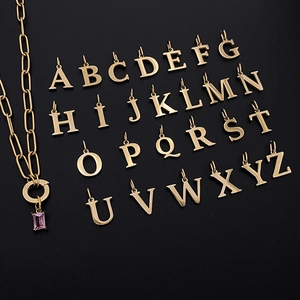 Detailansicht von 26 goldenen Alphabet-Anhängern A-Z mit rosa Zirkonia
