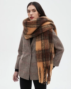 Detail showing thick brown plaid wool scarf with decorative tassels for autumn and winter