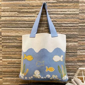 Blue and white knitted octopus tote bag with marine theme motifs and sturdy woven handles