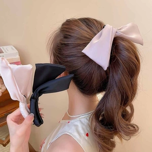 Détail de nœuds à cheveux élégants en satin noir et rose pour coiffure en queue de cheval