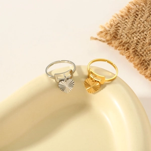 Detail of heart pendant rings in gold and silver finish on a ceramic tray