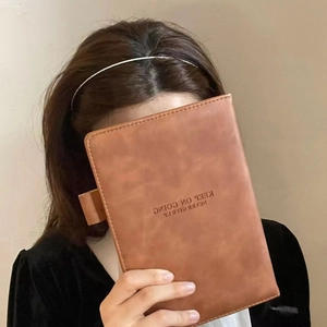 Detail of brown leather notebook cover featuring Keep On Going text and a pen loop