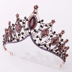 Close-up of vintage bronze crown with deep red crystals and purple rhinestones