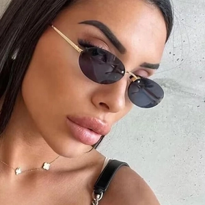 Chic Y2K rimless oval sunglasses with gold metal temples worn by a model in outdoor light