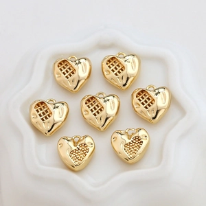 Detailed macro of gold-plated heart charms with grid texture for DIY jewelry making