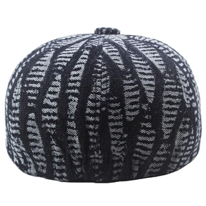 Macro detail of textured black and white jacquard pattern on a retro newsboy cap