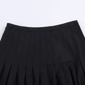 Vue détaillée des plis de la taille et du tissu d'une jupe mi-longue plissée noire