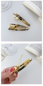 Detail of tortoise shell acetate cat-ear and waterdrop hair clips with gold metal base
