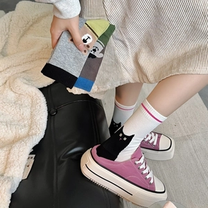 Detail of combed cotton mid-calf socks featuring colorful cartoon animal patterns