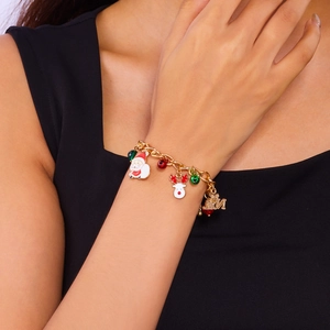 Detail of Christmas bracelet with gold NOEL charms, Santa, and elk on woman's wrist
