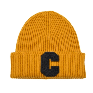 Detail of ginger yellow ribbed knit beanie showing C letter patch and textured fabric