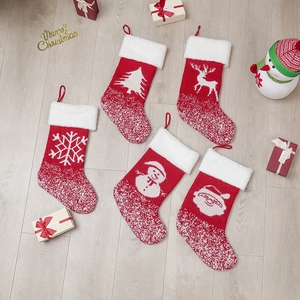 Set mit fünf roten gestrickten Weihnachtssocken mit festlichen Mustern auf hellem Holz
