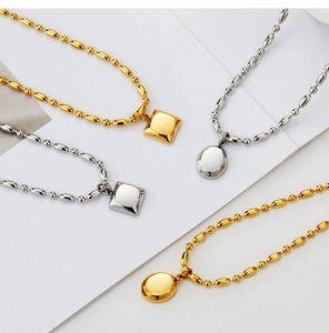 Disposition artistique de colliers en or et argent avec pendentifs géométriques