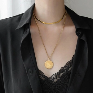 Layered gold snake bone chain necklace with a circular prayer gesture pendant for women