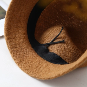 Close-up of the internal adjustable drawstring and sweatband in a brown knit hat
