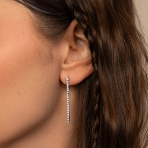 Élégantes boucles d'oreilles pendantes en zircone argentées sur un mannequin