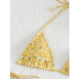 Detailed macro view of yellow daisy print smocked triangle bikini top with textures