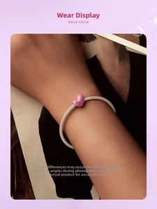 Vue détaillée d'un bracelet en maille argentée avec un pendentif cœur rose gravé Love
