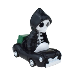 Detail of Halloween skeleton toy in a vintage black car with green accents