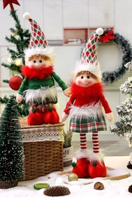 Close-up of plush Christmas elf dolls in red and green outfits for festive table decoration