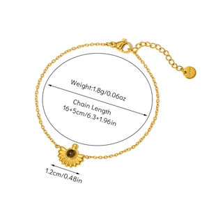 Detailed view of 18K gold plated chain bracelet with sunburst fan pendant and tiger eye stone