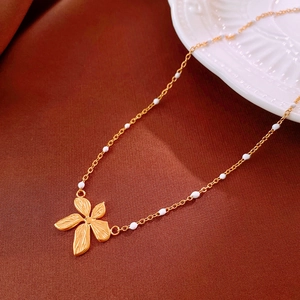 Detail of flower pendant necklace with white beads on textured brown fabric