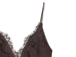 Close-up of deep brown satin dress with intricate eyelash lace trim and thin straps