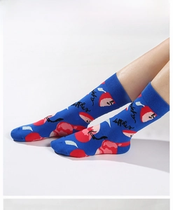 Détail de chaussettes bleu vif avec motifs de pommes rouges et revers côtelés