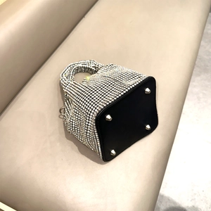 Detail view of the black rhinestone handbag base featuring four silver metal protective studs