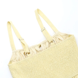 Détail de la robe smockée jaune avec bretelles spaghetti réglables et boucles en métal