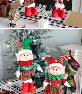 Christmas elf dolls in red and green stripes placed under a festive Christmas tree