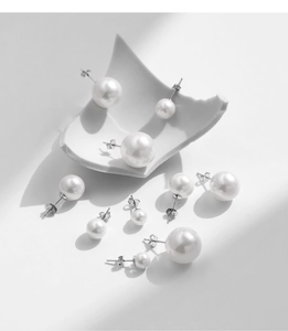 Detail of S925 sterling silver pearl studs in multiple sizes on white porcelain