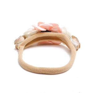 Detail of soft peach fabric floral headband with elastic band for infants and toddlers